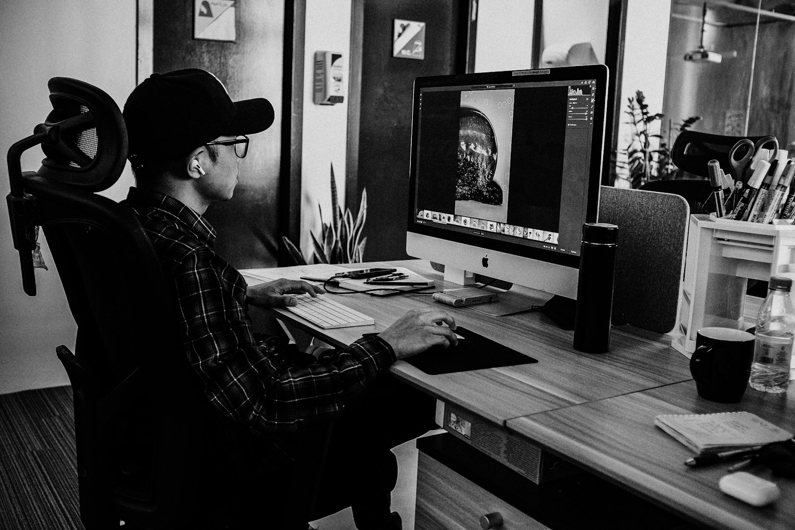 A person working at a computer in a monochrome office